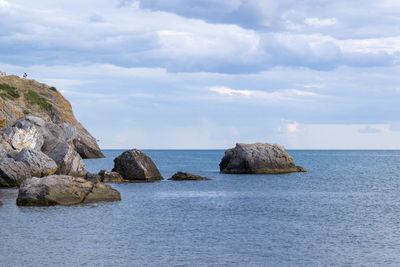 Rocks in sea against sky