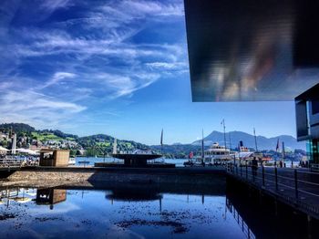 Boats moored at harbor against sky