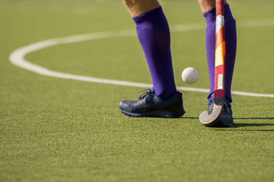 Low section of man playing hockey on field