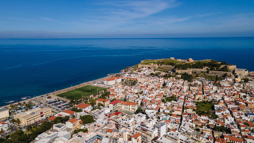 High angle view of townscape by sea against sky