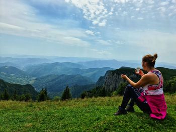 Woman sitting on mountain looking at view