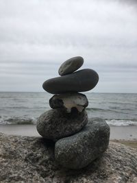 Stack of stones on beach against sky