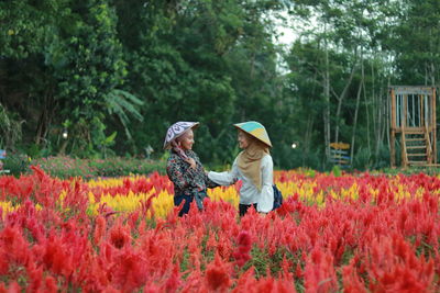 Rear view of people on flowering plants