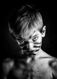 Close-up portrait of shirtless boy with face paint