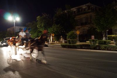 Man riding motorcycle on road at night