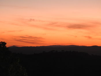 Scenic view of dramatic sky over silhouette landscape