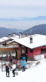 People on snow covered mountain against sky