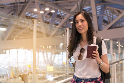 Portrait of smiling young woman standing at airport