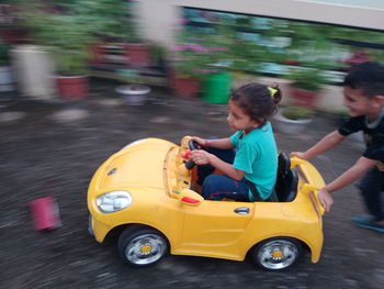 Rear view of boy riding toy car