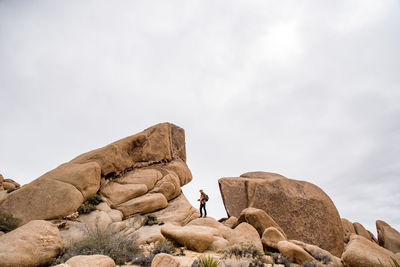 Man rock on rocks against sky