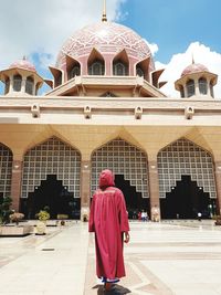 Rear view of man walking in temple against building