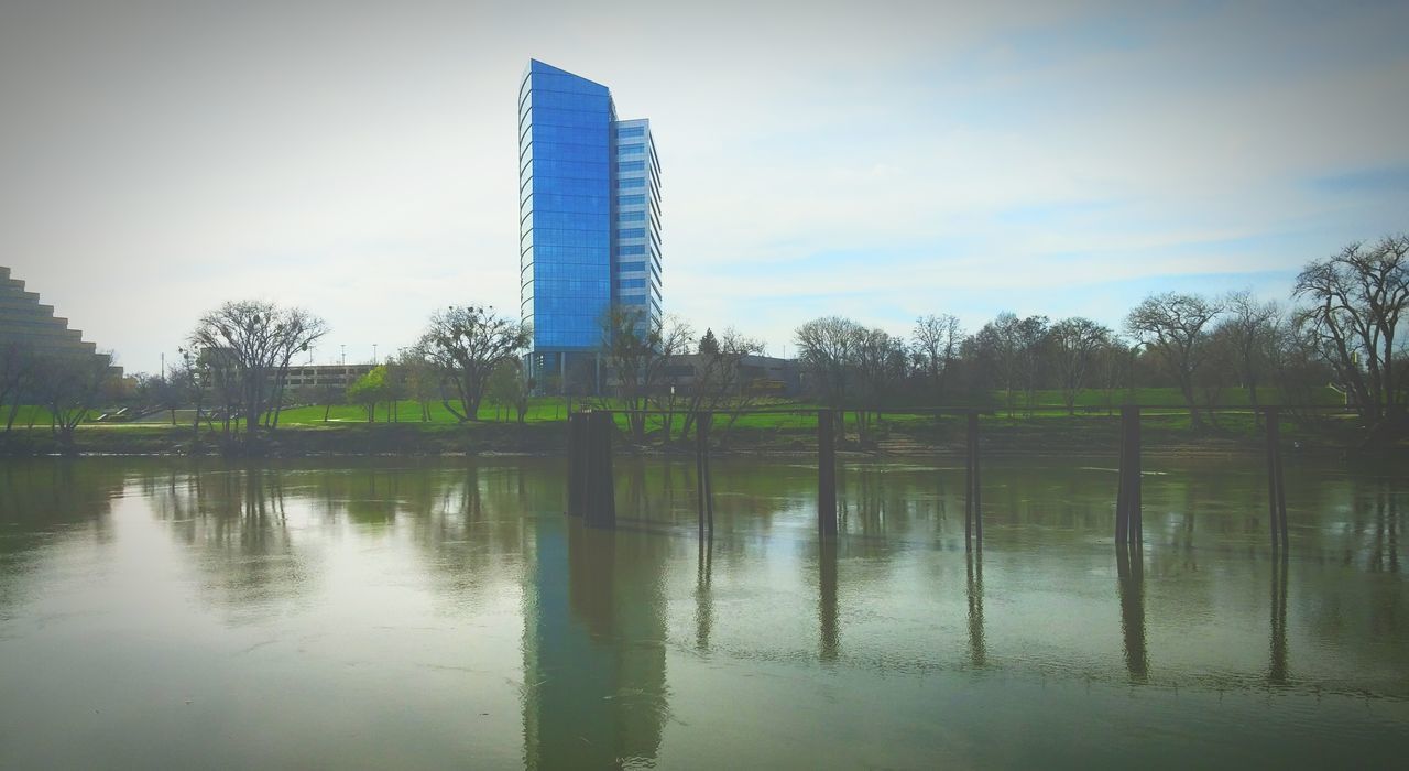 water, reflection, architecture, built structure, sky, building exterior, waterfront, tree, lake, tranquility, cloud - sky, nature, tower, day, tall - high, river, no people, outdoors, cloud, growth