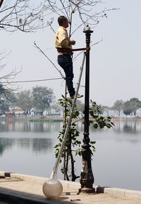 Electrician repairing street light at truc bach lake