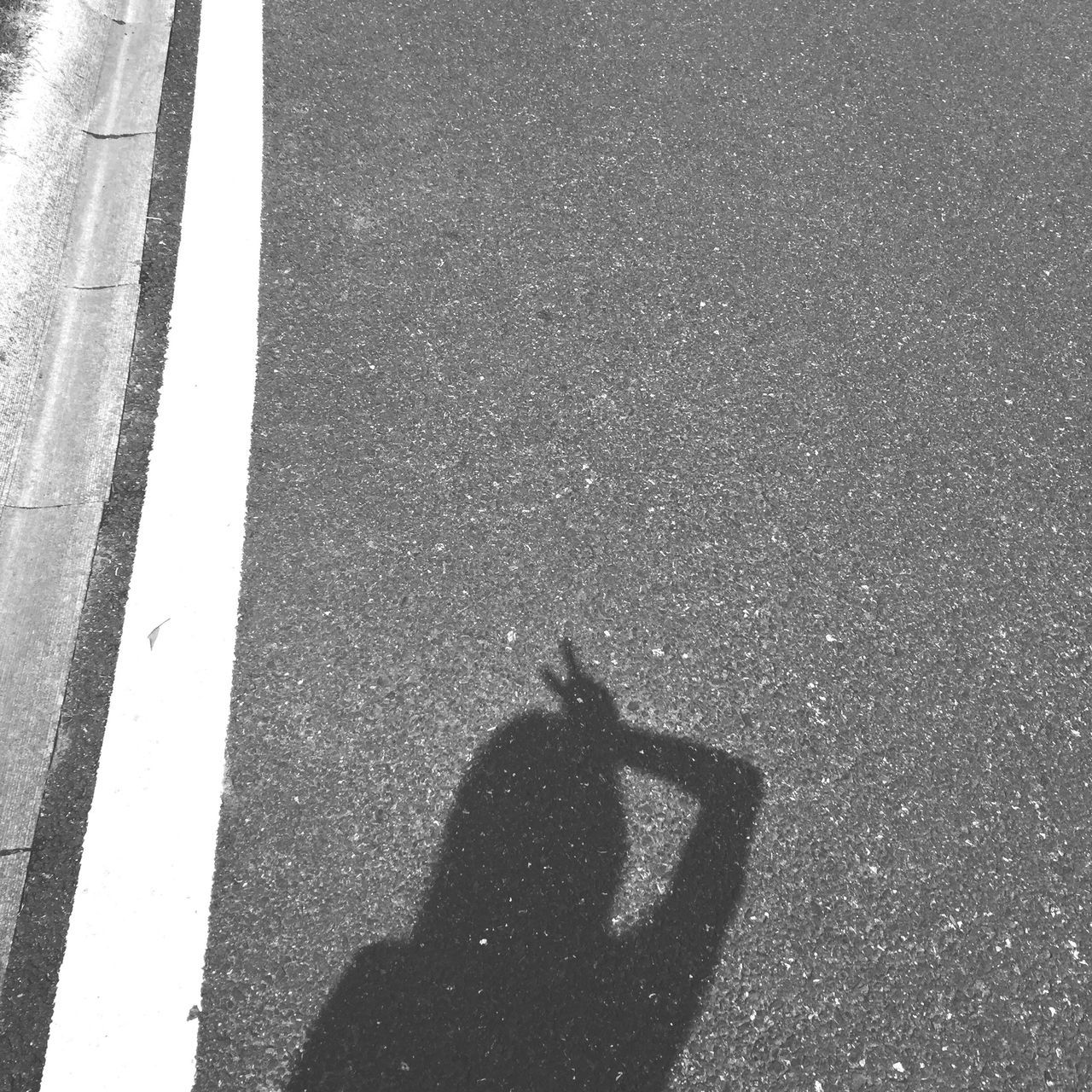 transportation, asphalt, shadow, road marking, road, taken on mobile device, texture, person, peace sign, outdoors, limb, day, in front of, tranquil scene