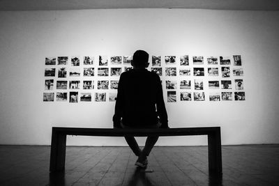 Rear view of man sitting on seat at home