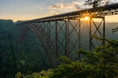 Bridge over river against sky during sunset