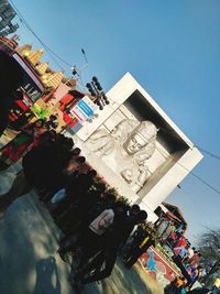 Low angle view of people hanging against clear sky