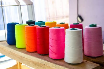 Close-up of multi colored thread spools on table