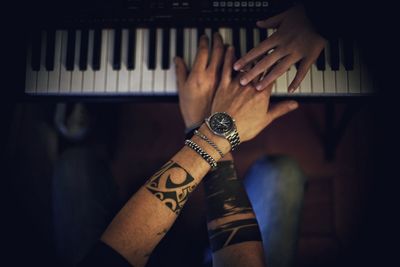 Midsection of man playing piano