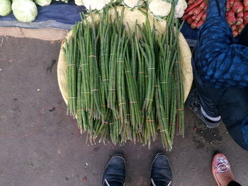 Cropped image of people buying vegetables at market