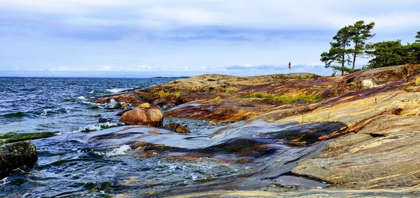 Rocks by sea against sky