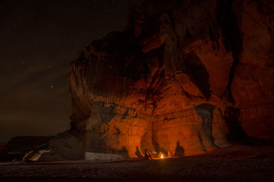 People sitting on rock at night