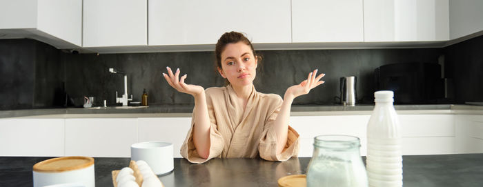 Portrait of young woman sitting on table