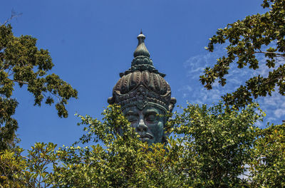 Low angle view of statue against blue sky