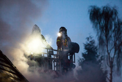 Low angle view of fire brigade on balcony against sky