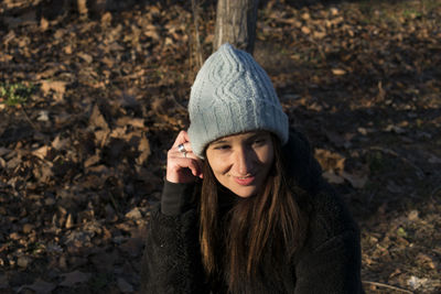 Woman wearing knit hat sitting outdoors