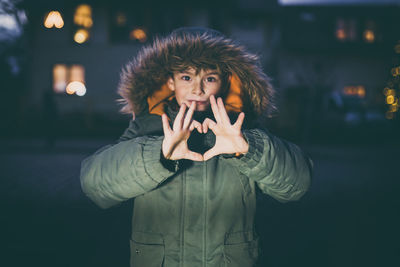 Portrait of young woman with heartshape hands