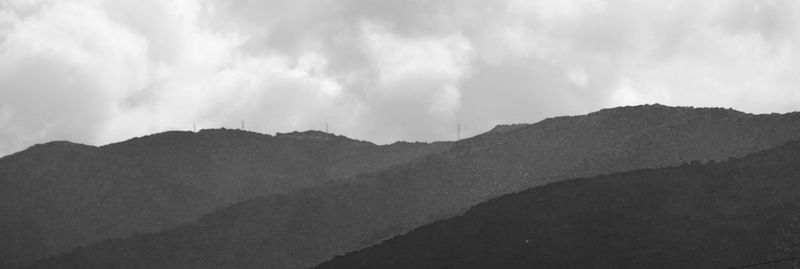 Scenic view of mountains against cloudy sky