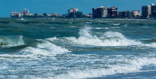 Scenic view of sea against buildings in city