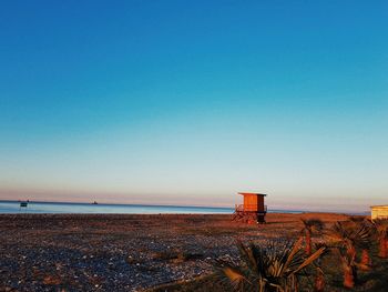 Lifeguard hut at beach against blue sky