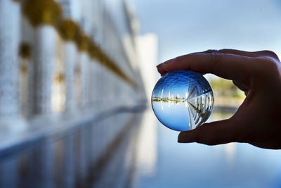 Close-up of hand holding ball with reflection