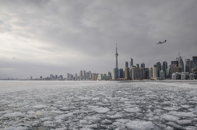 Frozen lake ontario by urban skyline