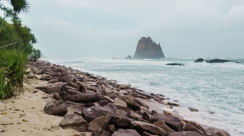 Rocks on beach against sky