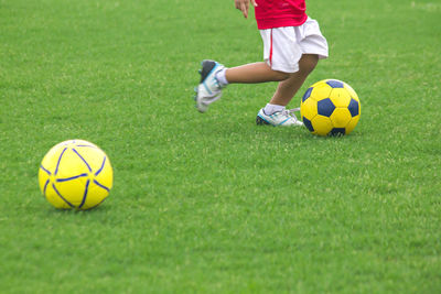 Low section of boy playing soccer on field