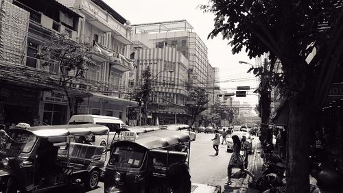 Cars on city street against clear sky