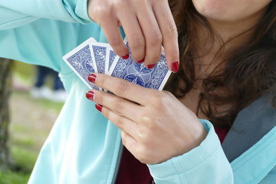 Midsection of woman playing cards