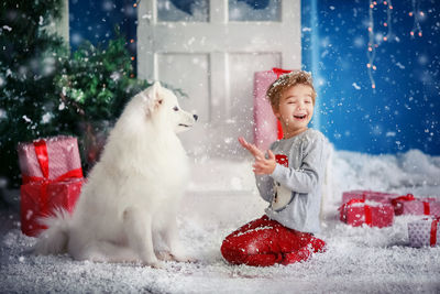 Portrait of woman with dog on snow