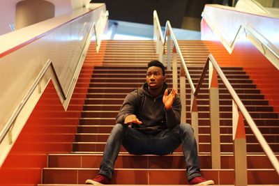 Portrait of young man sitting on steps