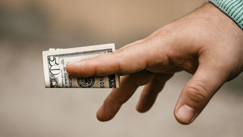 Cropped hand of person holding paper currency