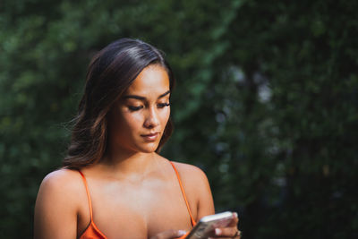 Portrait of beautiful young mixed race woman using cell phone.