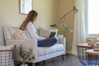 Woman sitting on sofa at home