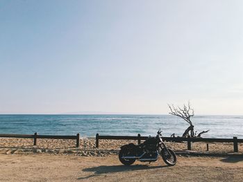 Bicycles on beach against clear sky