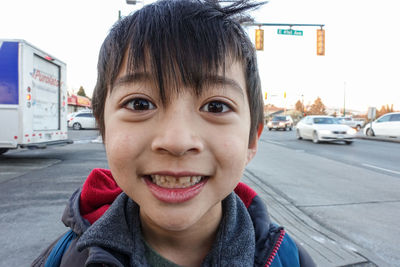 Portrait of smiling boy on street in city