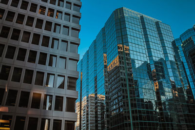 Low angle view of modern buildings against blue sky