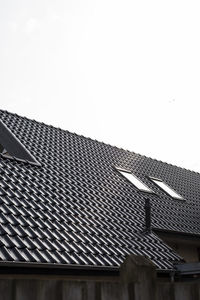 Low angle view of building roof against clear sky