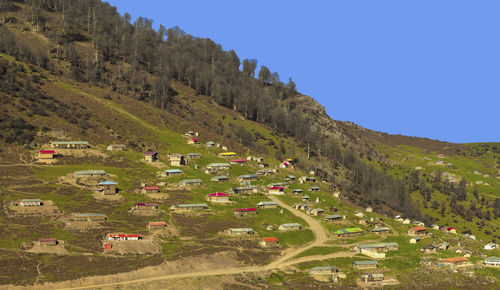 Aerial view of landscape and buildings against clear blue sky
